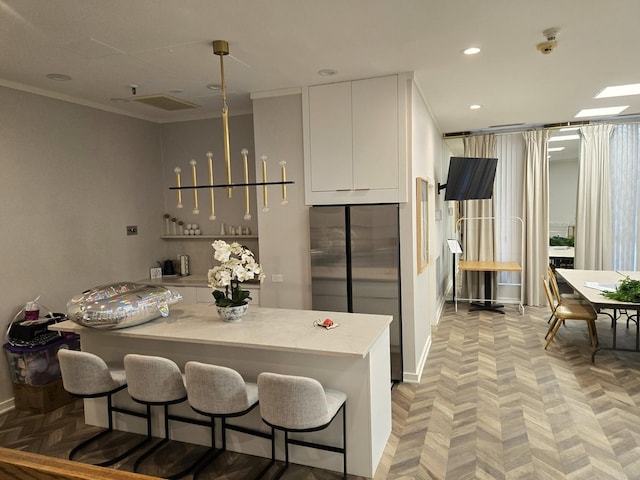 kitchen featuring recessed lighting, light countertops, freestanding refrigerator, white cabinets, and modern cabinets