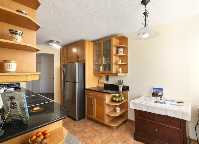 kitchen with pendant lighting, open shelves, dark countertops, glass insert cabinets, and freestanding refrigerator