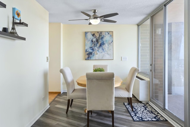 dining room featuring a textured ceiling, wood finished floors, a ceiling fan, and baseboards