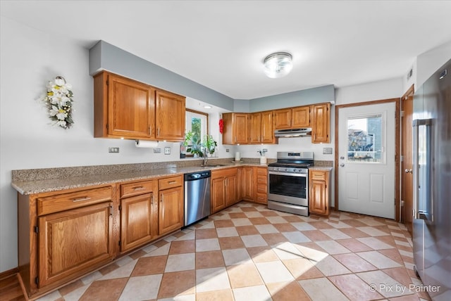 kitchen featuring light stone counters, plenty of natural light, and stainless steel appliances