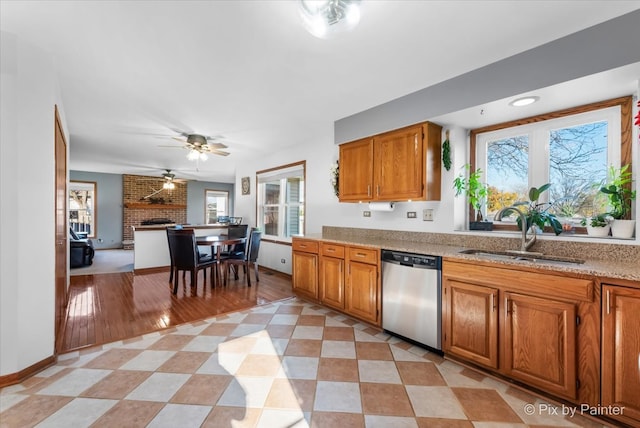 kitchen with dishwasher, sink, a wealth of natural light, and light hardwood / wood-style flooring