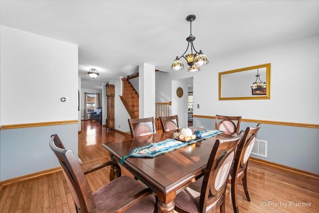 dining area with a chandelier and light hardwood / wood-style flooring