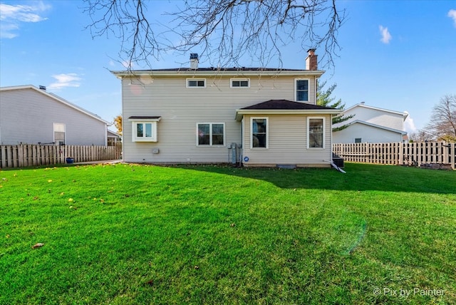 rear view of property with a lawn