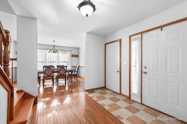 entrance foyer with light hardwood / wood-style flooring and an inviting chandelier