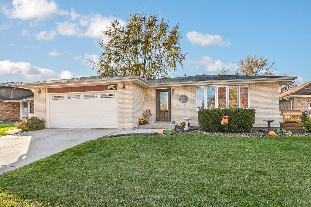 single story home featuring a garage and a front yard