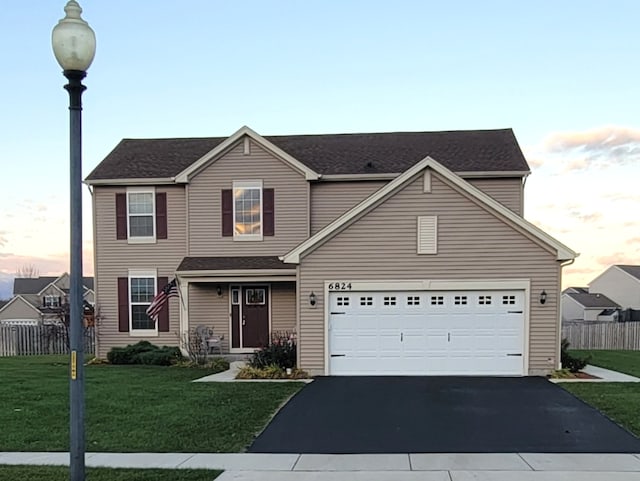 front facade featuring a garage and a yard