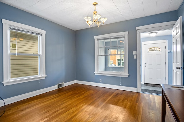 foyer entrance with wood-type flooring and a notable chandelier