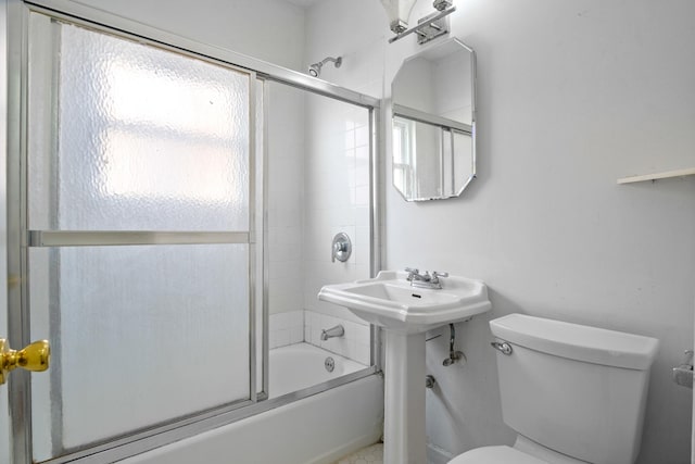 full bathroom featuring sink, toilet, and bath / shower combo with glass door