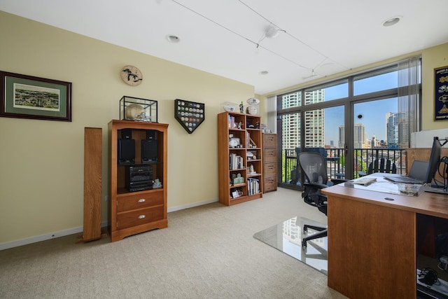 carpeted home office featuring floor to ceiling windows