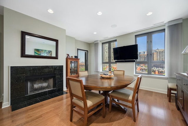 dining area with a premium fireplace and light hardwood / wood-style flooring