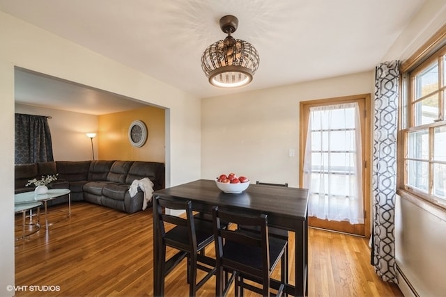 dining room with wood-type flooring and a baseboard heating unit