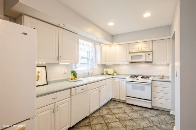 kitchen featuring white cabinetry, sink, and white appliances