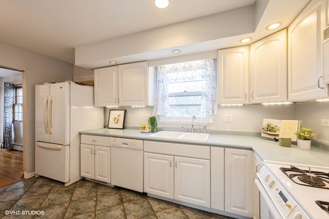 kitchen featuring sink, white cabinets, and white appliances