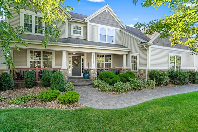 craftsman-style home with a porch and a front lawn