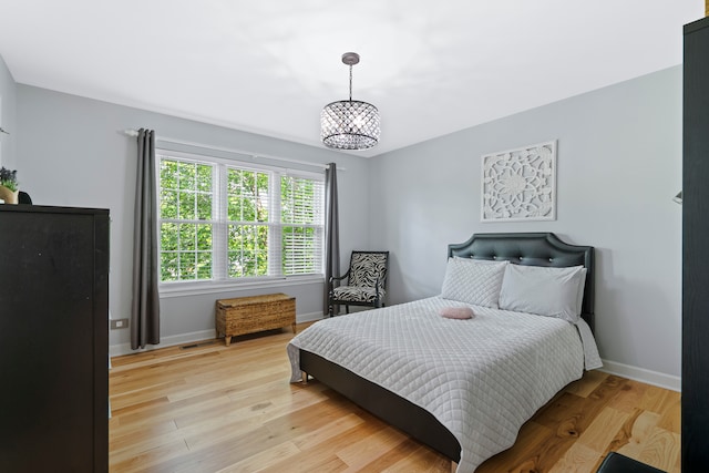 bedroom featuring a chandelier and light hardwood / wood-style flooring