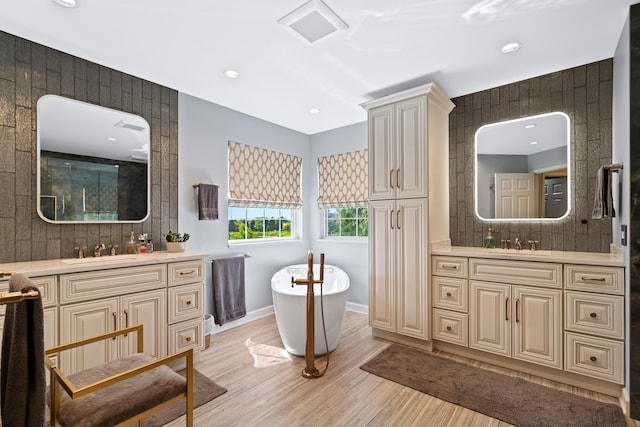 bathroom with decorative backsplash, a bath, hardwood / wood-style flooring, and vanity