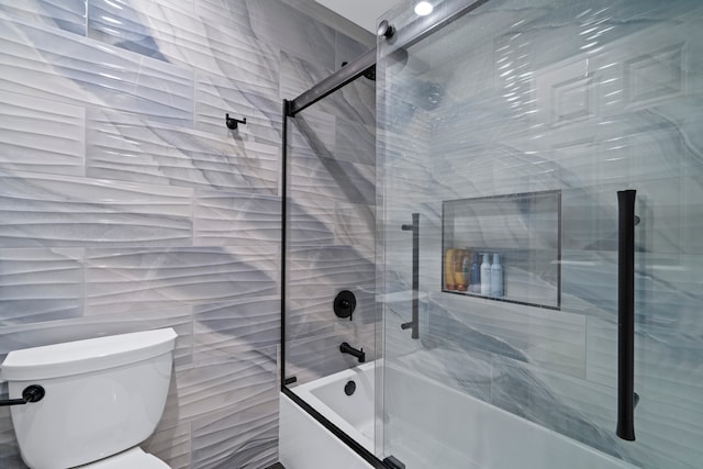 bathroom with combined bath / shower with glass door and toilet