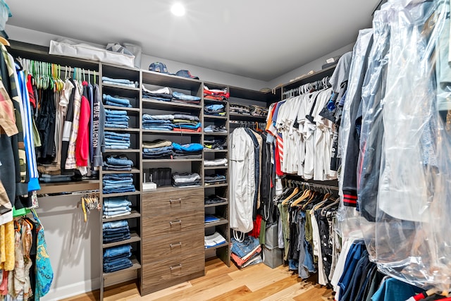 walk in closet with light hardwood / wood-style flooring