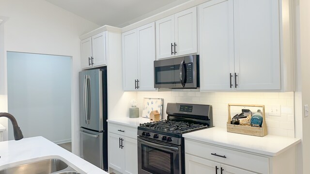 kitchen featuring stainless steel appliances, white cabinetry, sink, and decorative backsplash