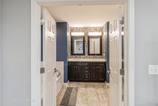 bathroom with vanity, decorative backsplash, and a washtub