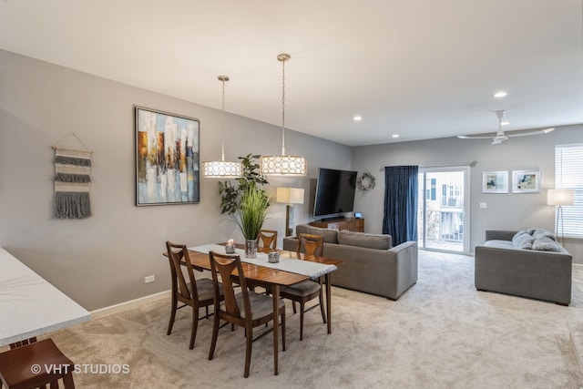 dining space featuring light colored carpet and ceiling fan