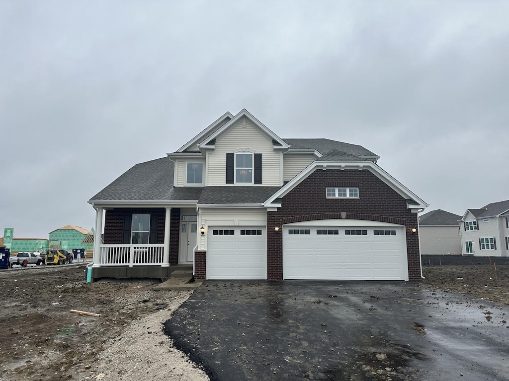 view of front facade featuring covered porch and a garage