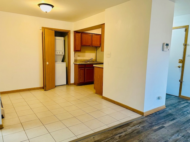 interior space featuring light hardwood / wood-style floors, sink, and stacked washer and dryer