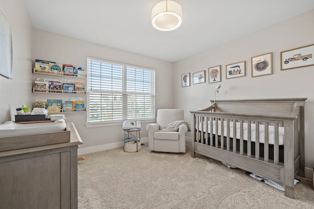 bedroom featuring light carpet and a nursery area