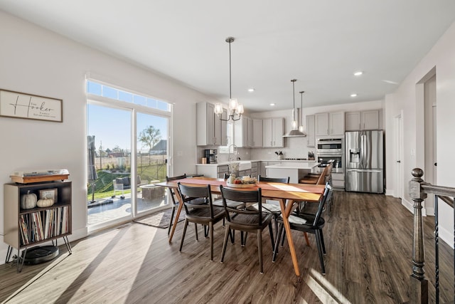 dining space with wood-type flooring, a healthy amount of sunlight, and sink