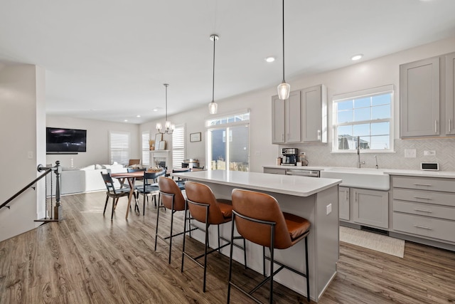 kitchen featuring hardwood / wood-style flooring, a center island, gray cabinets, and plenty of natural light