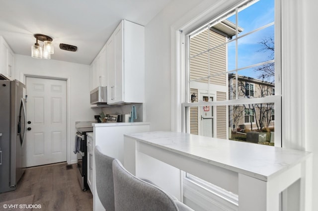 laundry area featuring washer and dryer, dark hardwood / wood-style flooring, and cabinets