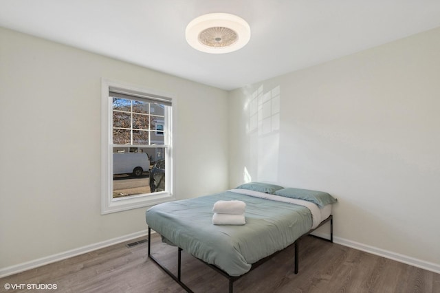 bedroom with multiple windows and hardwood / wood-style floors