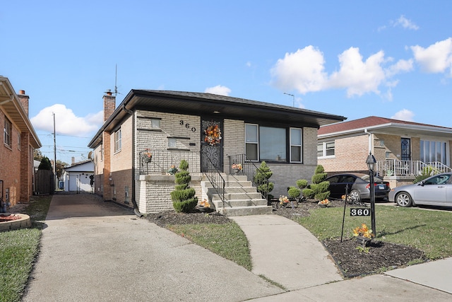 view of front of property featuring an outbuilding, a garage, and a front yard