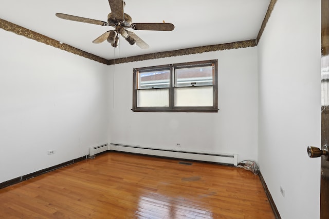 empty room with hardwood / wood-style flooring, ceiling fan, and a baseboard heating unit