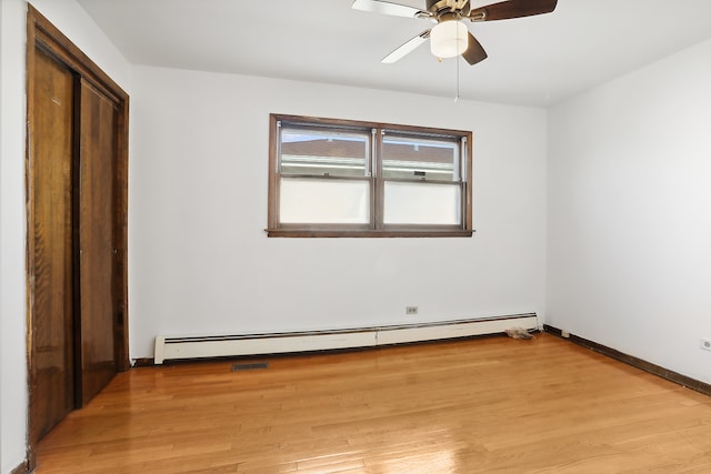 unfurnished room with a baseboard heating unit, light hardwood / wood-style floors, and ceiling fan