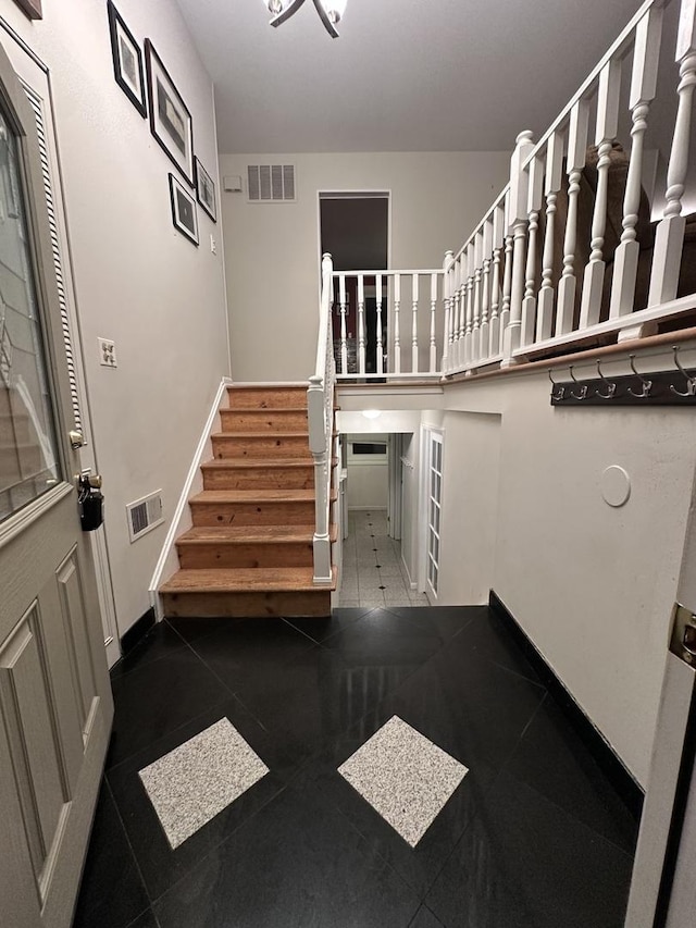 foyer entrance featuring dark tile patterned flooring