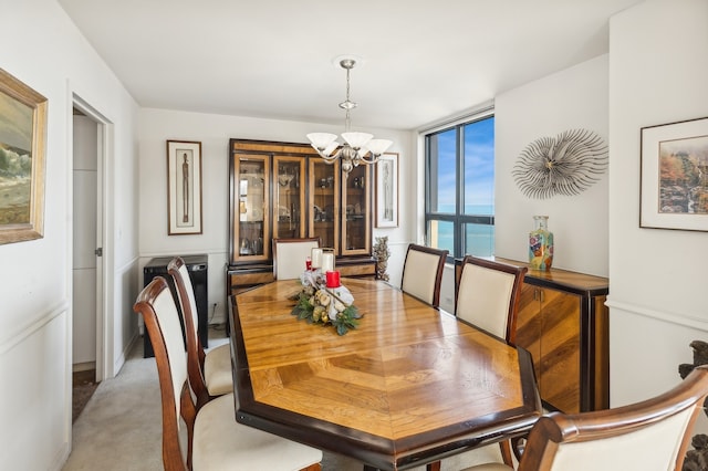 dining space with carpet flooring, a wealth of natural light, a water view, and a chandelier