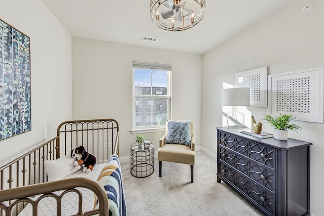 carpeted bedroom featuring a nursery area