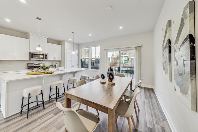 dining space featuring light hardwood / wood-style flooring and sink