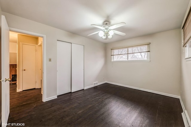 unfurnished bedroom featuring ceiling fan, dark wood-type flooring, and a closet