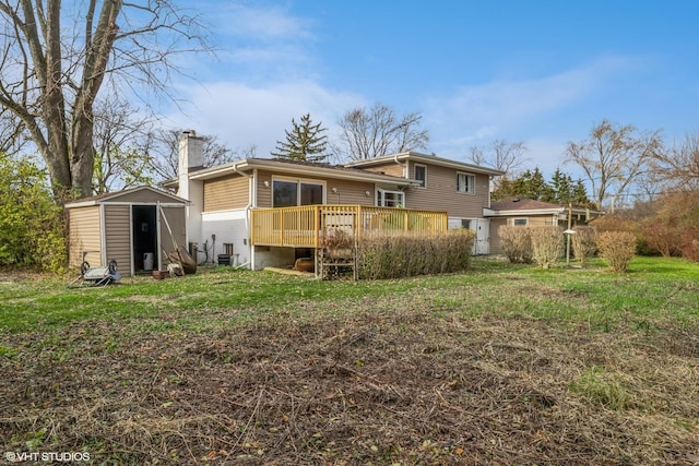 rear view of property with a yard, a deck, and a shed