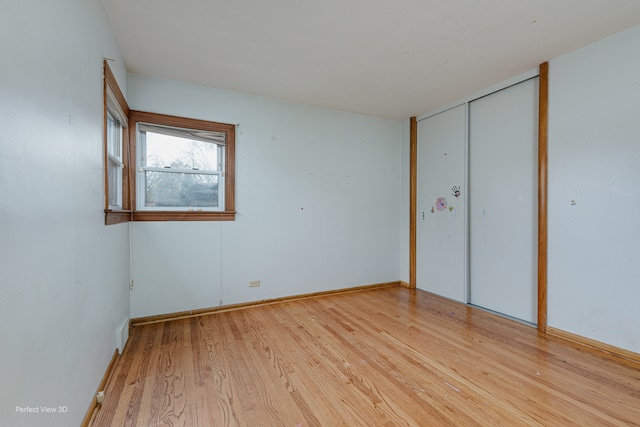 unfurnished bedroom with a closet and light hardwood / wood-style flooring