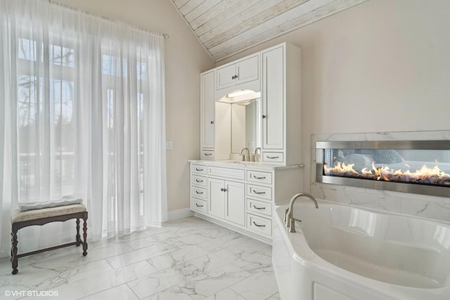 full bathroom featuring marble finish floor, wooden ceiling, a bath, vanity, and vaulted ceiling