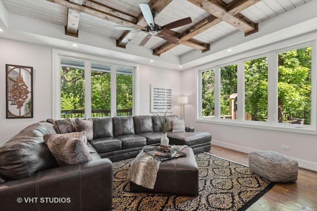 living area featuring baseboards, ceiling fan, hardwood / wood-style flooring, wood ceiling, and beamed ceiling