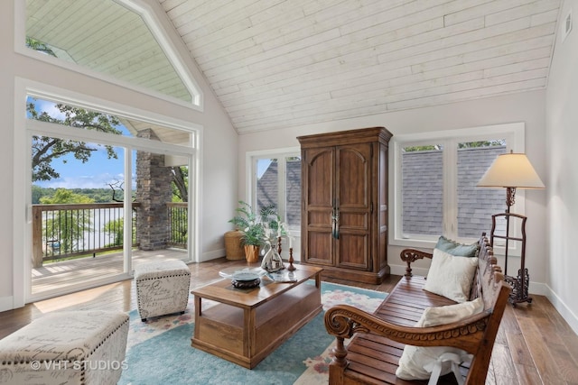 living area with baseboards, wood finished floors, wooden ceiling, and vaulted ceiling