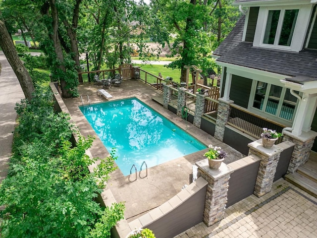 view of pool with a fenced in pool and a diving board