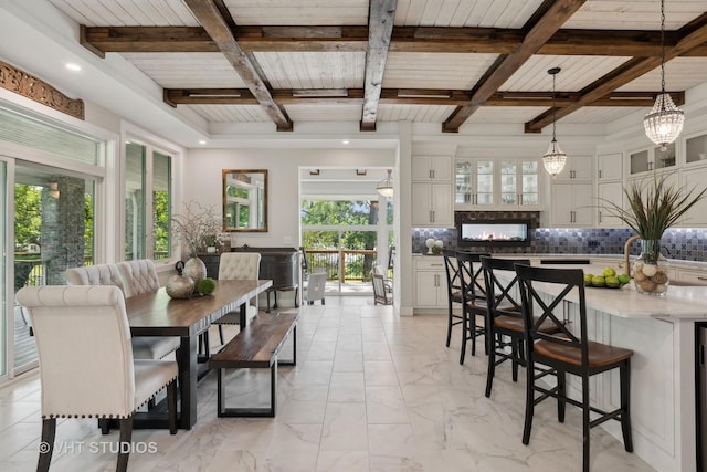 dining space with beam ceiling, coffered ceiling, and marble finish floor