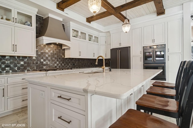 kitchen featuring custom exhaust hood, gas stovetop, a sink, dobule oven black, and high end refrigerator