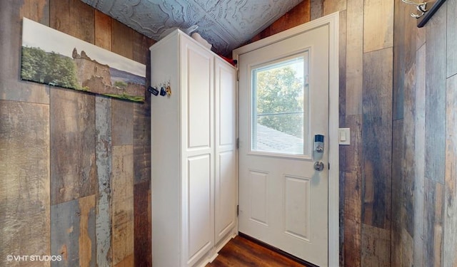 doorway to outside with dark wood-type flooring and vaulted ceiling