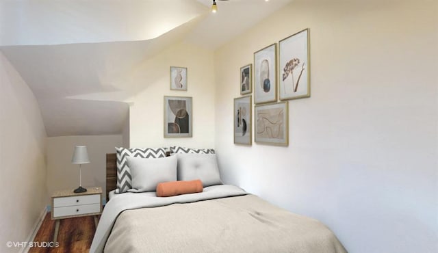 bedroom with lofted ceiling and dark hardwood / wood-style floors